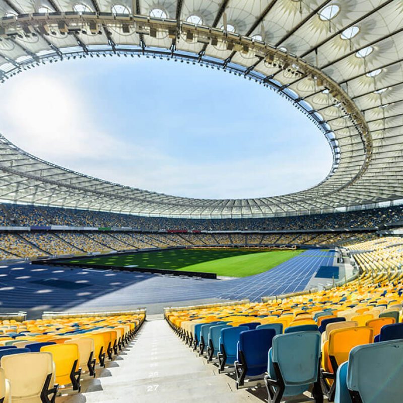 rows-of-yellow-and-blue-stadium-seats-on-soccer-fi-T7AKFMB.jpg